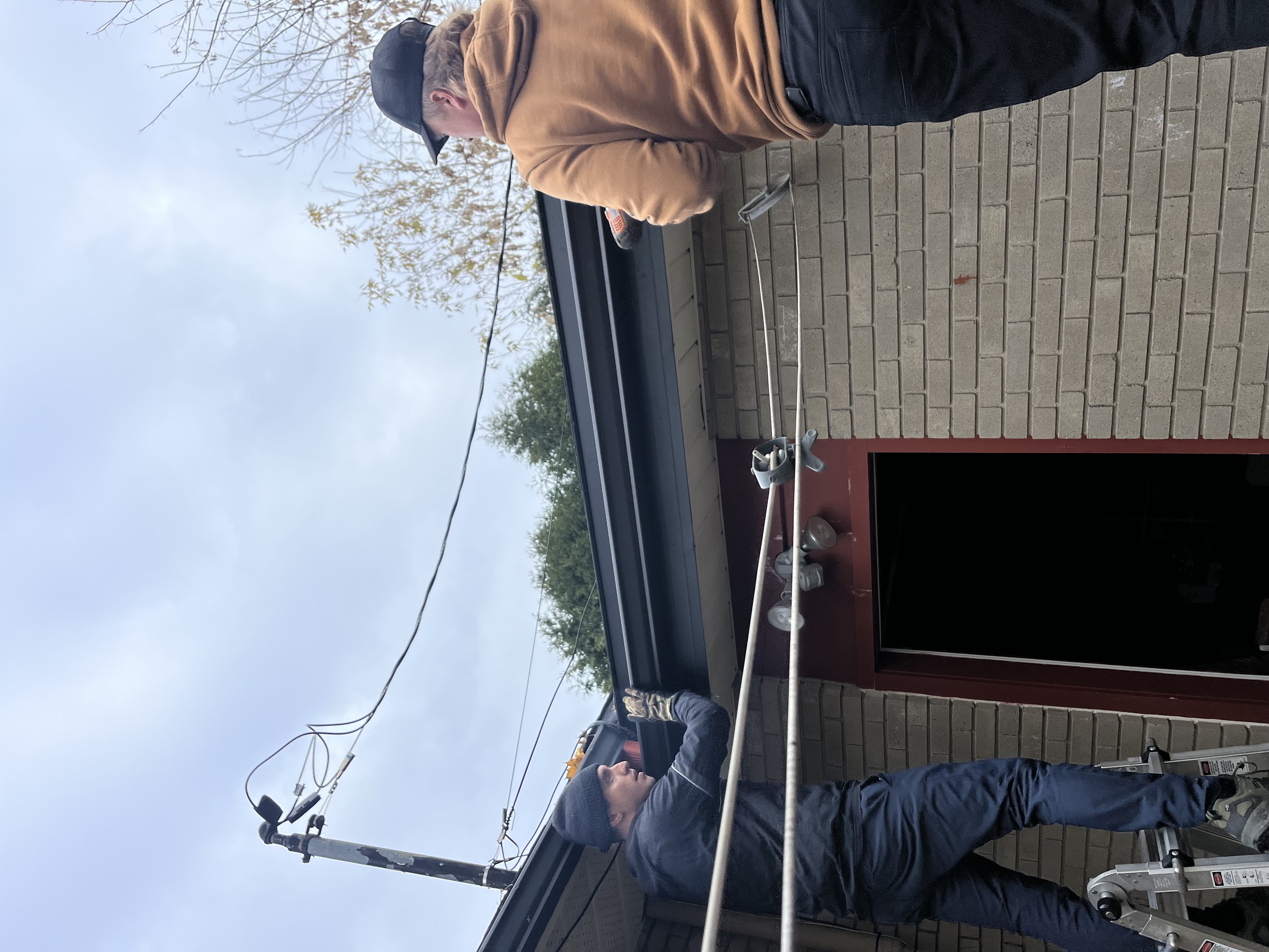 Two team members working on eavestrough installation