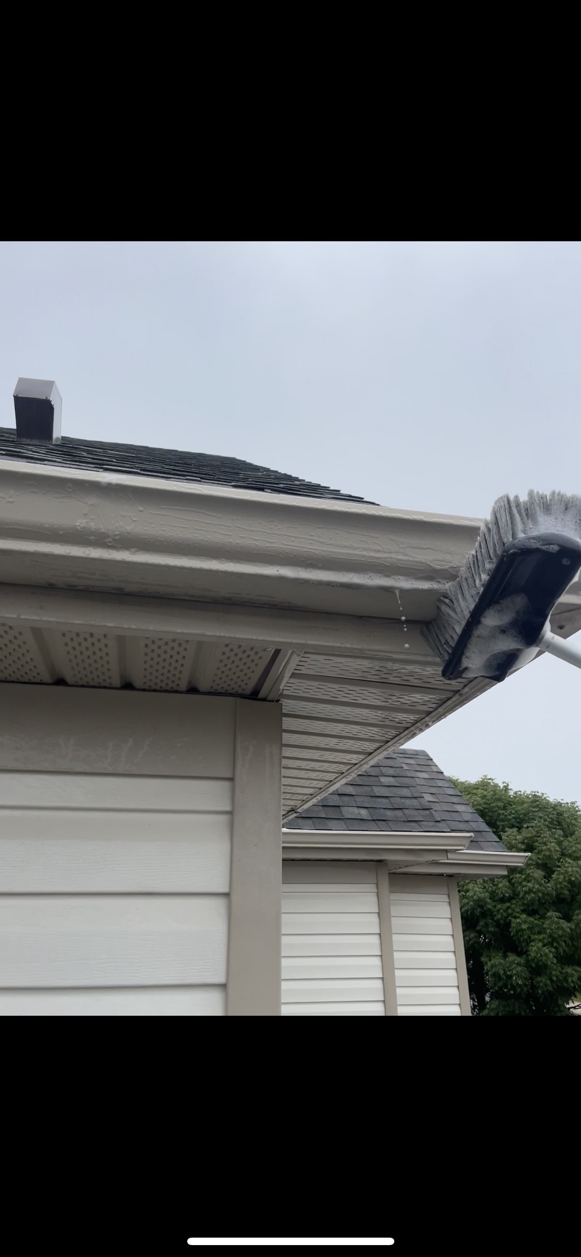 Brush scrubbing eavestrough fascia with foam