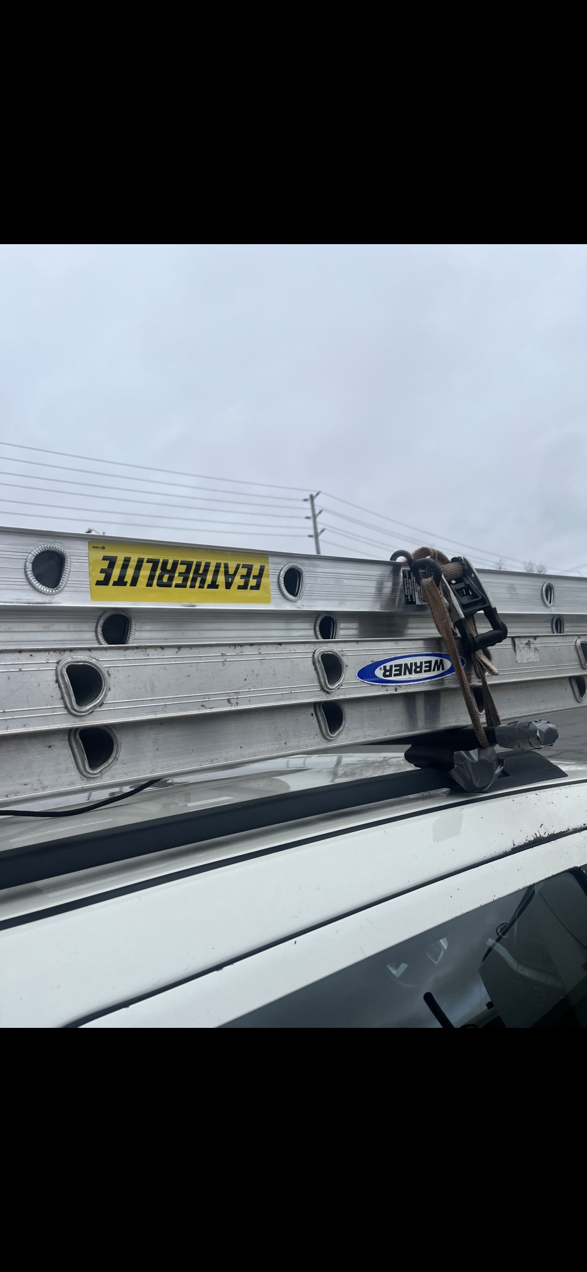 Featherlite and Werner ladders strapped to vehicle roof rack
